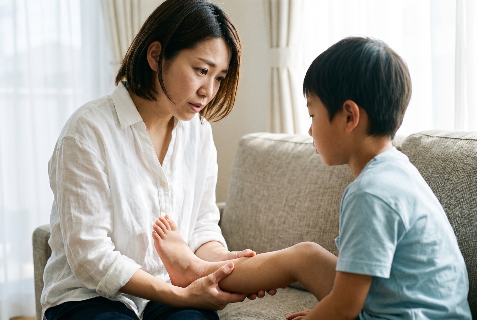子どもの足首の腫れ具合を確かめている母親