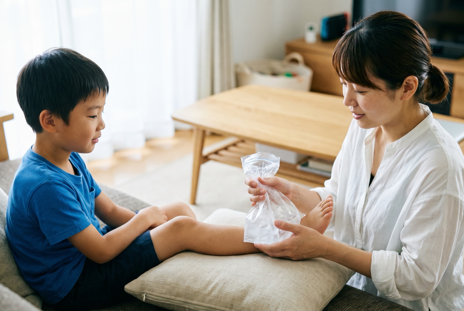 氷を入れたビニール袋で足首を冷やしている様子