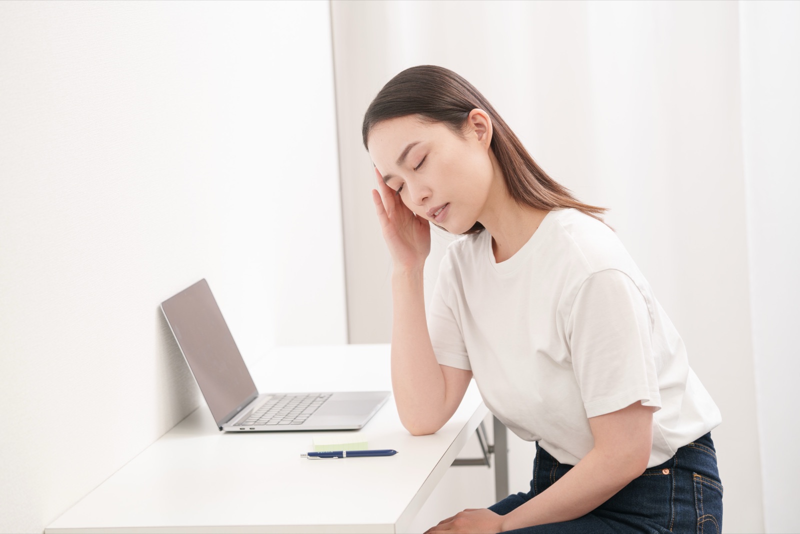 デスクで頭を抱えている女性