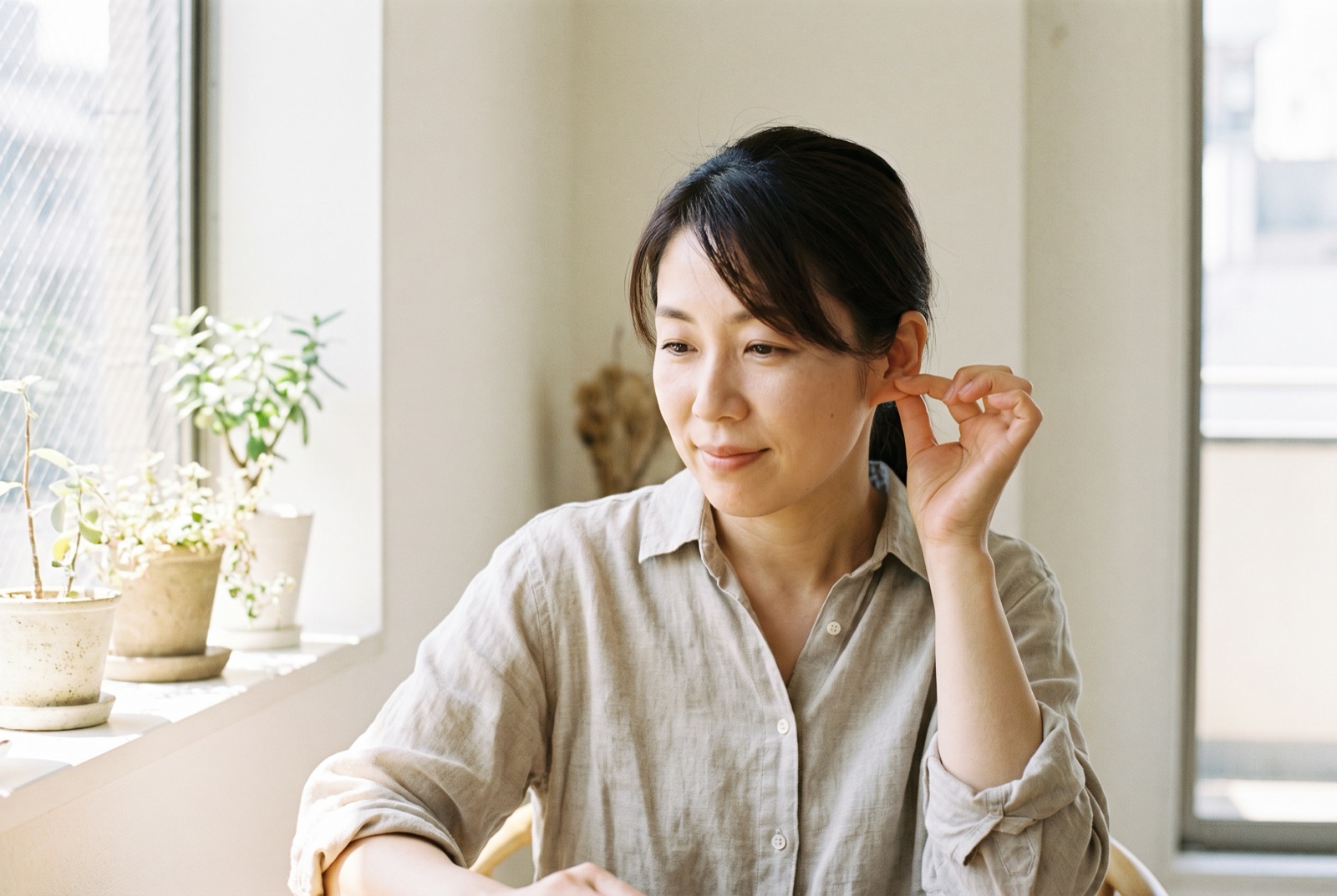 耳たぶを軽くつまんでいる女性