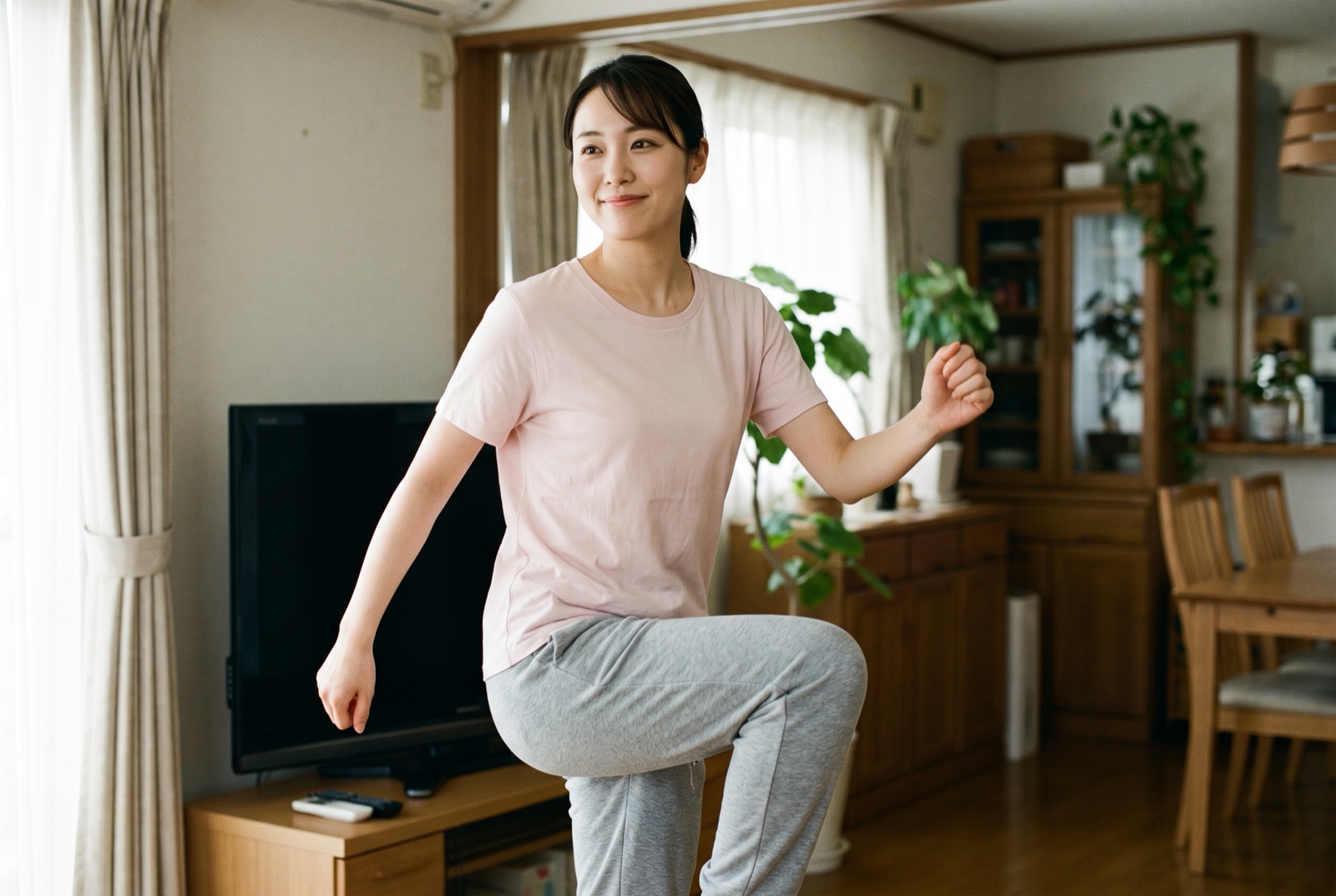テレビの前で、腕を軽く振りながらその場で足踏みをしている女性